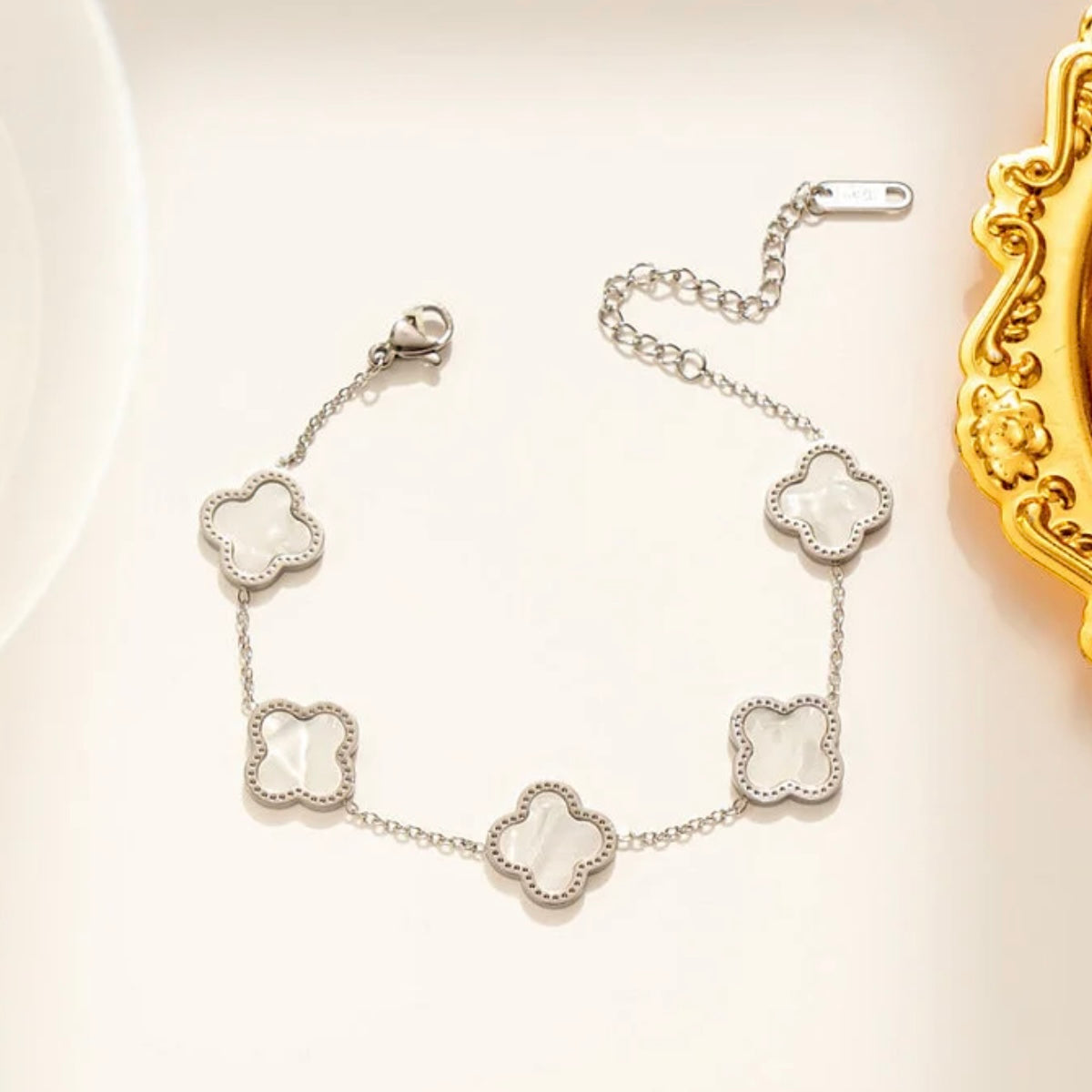 Silver bracelet with clover-shaped links on a light background