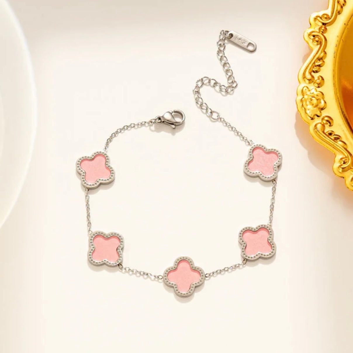 Pink clover-shaped bracelet on a light background