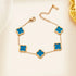 Gold bracelet with blue clover-shaped charms on a light background